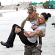 Houston Police SWAT officer Daryl Hudeck carries Catherine Pham and her 13-month-old son Aiden after rescuing them from their home surrounded by floodwaters from Tropical Storm Harvey on Aug. 27.